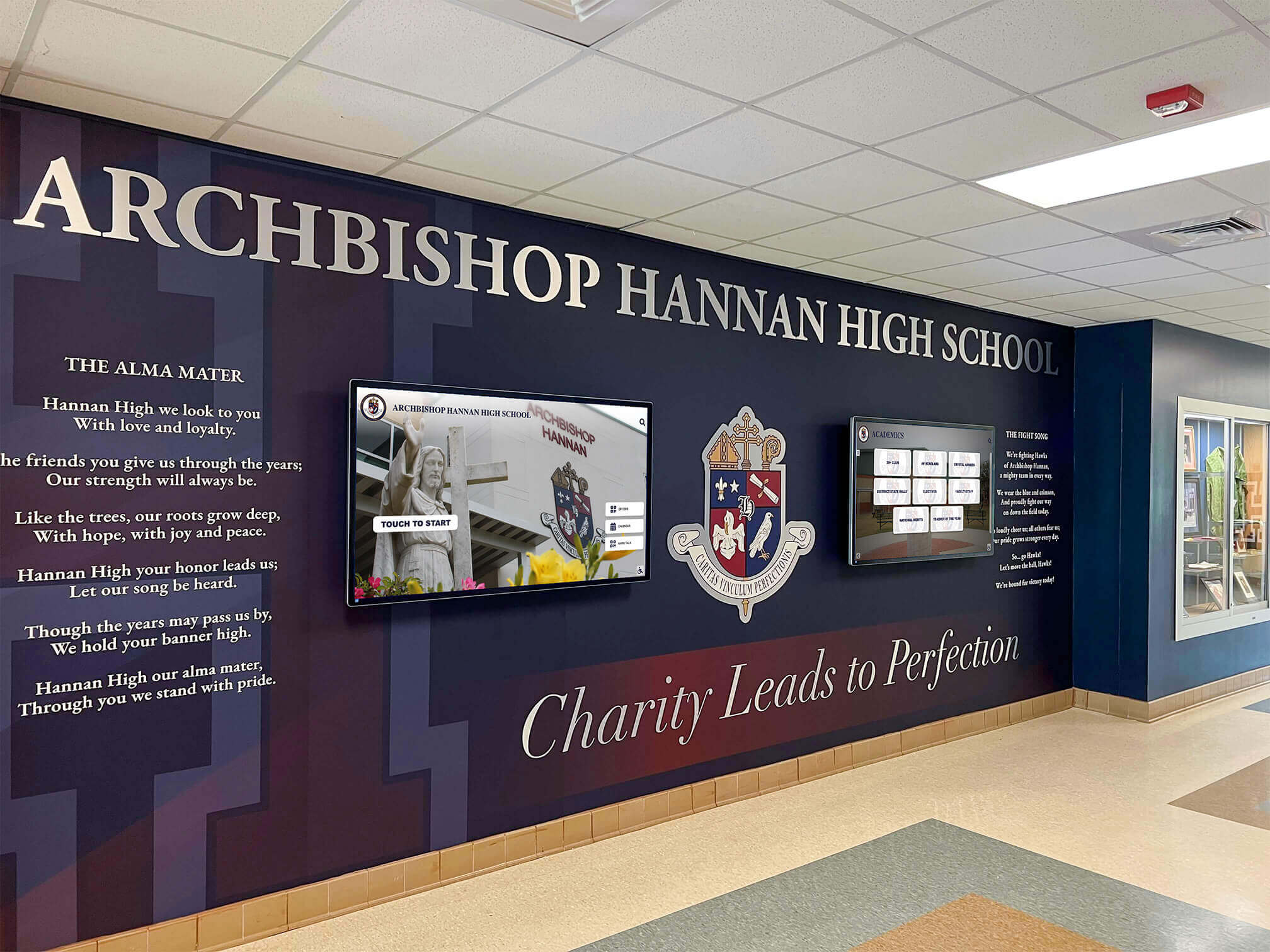 School lobby with digital displays and recognition mural