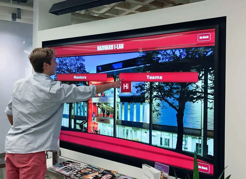 Interactive touchscreen directory at Harvard showing mentors and teams menu