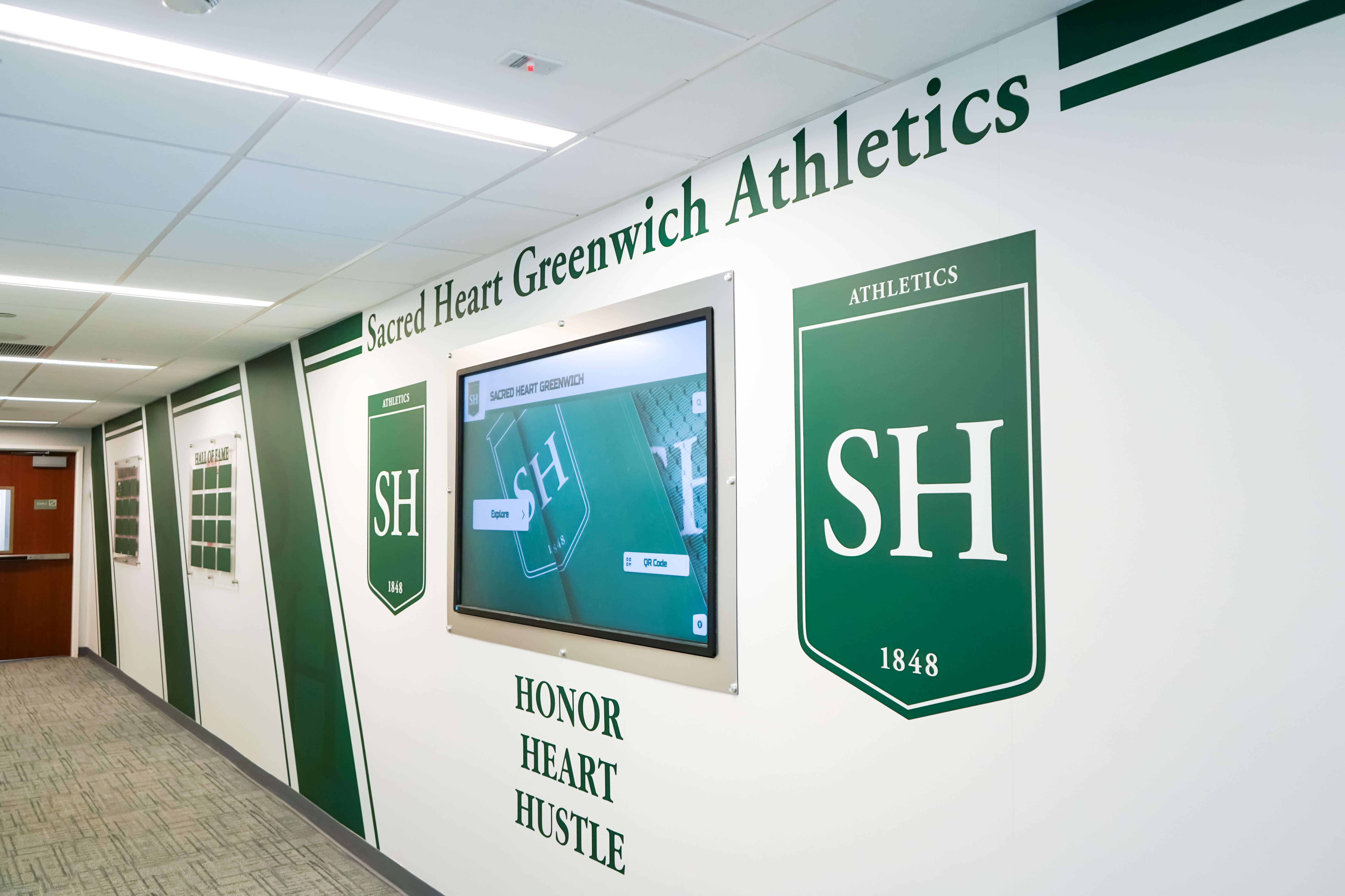 School athletics hallway with professional recognition displays and historical documentation